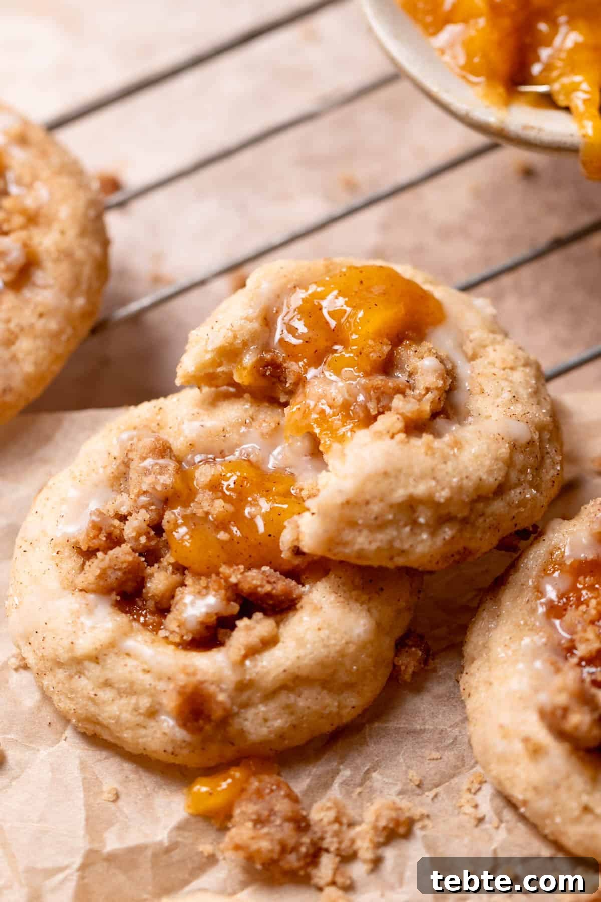 peach cookie with a bite taken out of it on parchment paper.