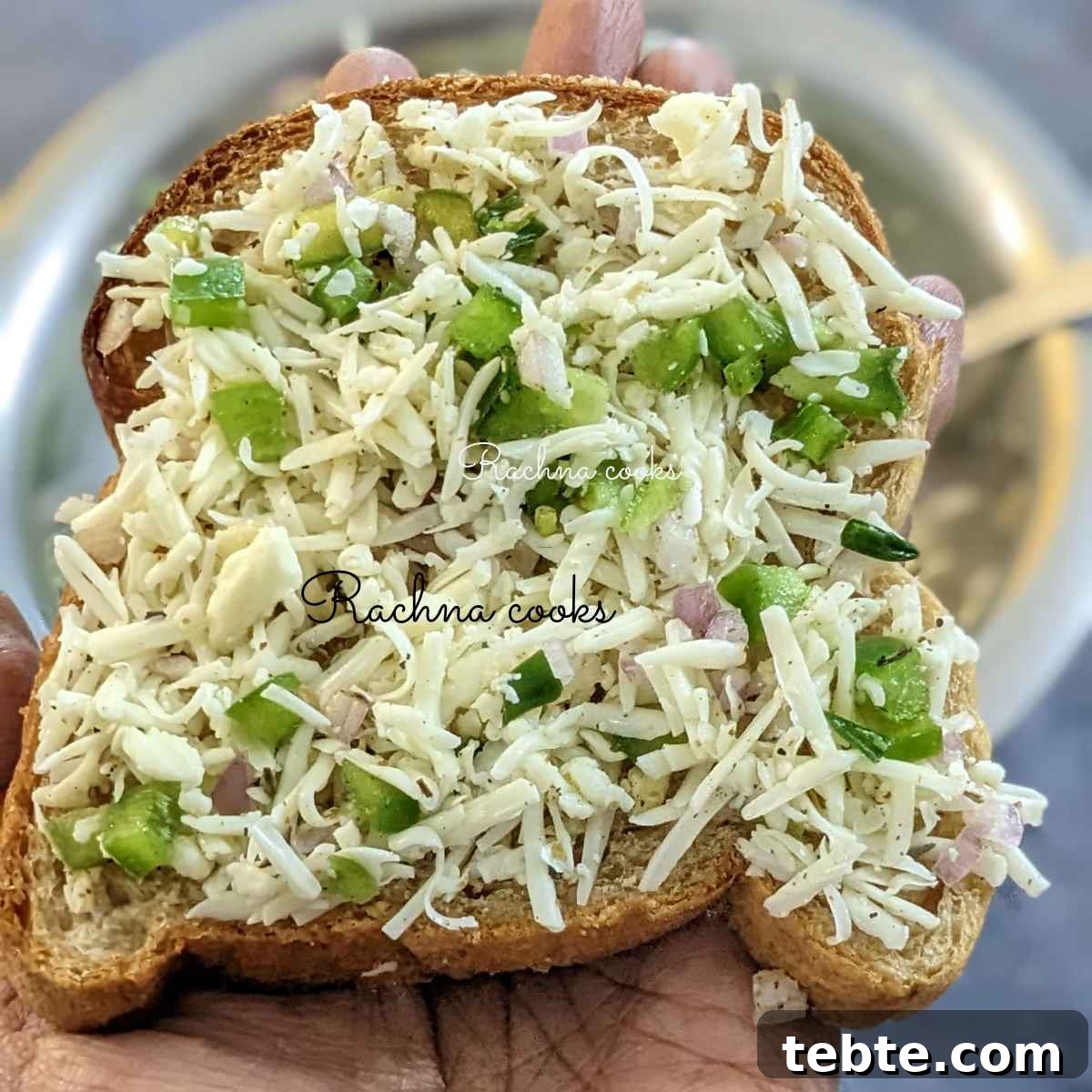 Spicy Chilli Cheese Toast Recipe for Quick Savory Snacks 6 One toast topped with cheesy topping held up in hand.