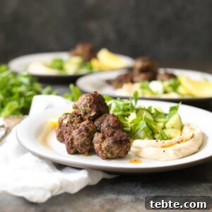 Spiced Lamb Kofta Recipe — Authentic Middle Eastern Meatballs 11 Three plated servings of lamb kofta with hummus and herbs.