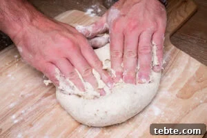 Crispy Garlic Pizza Bread Recipe — Cheesy Garlic Pull-Apart Loaf 9 Kneading the pizza bread dough by hands on a wooden chopping board