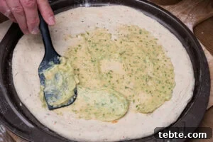 Crispy Garlic Pizza Bread Recipe — Cheesy Garlic Pull-Apart Loaf 14 Spreading the garlic butter mixture onto the pizza bread using a spatula