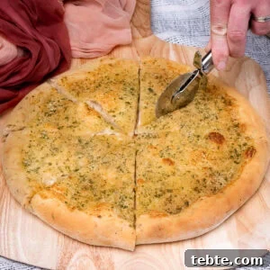 Crispy Garlic Pizza Bread Recipe — Cheesy Garlic Pull-Apart Loaf 4 Cutting the Garlic Pizza Bread with a pizza slicer