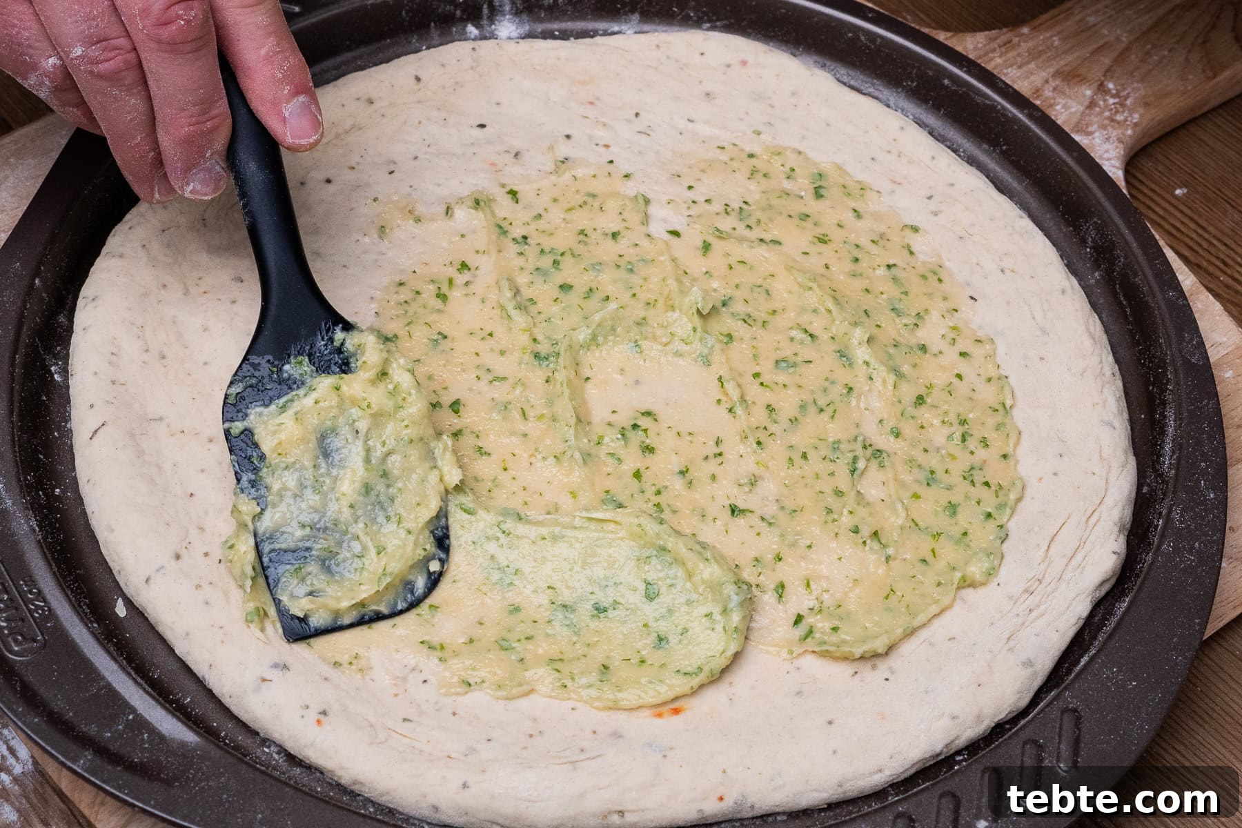 Crispy Garlic Pizza Bread Recipe — Cheesy Garlic Pull-Apart Loaf 30 Spreading the garlic butter mixture onto the pizza bread using a spatula