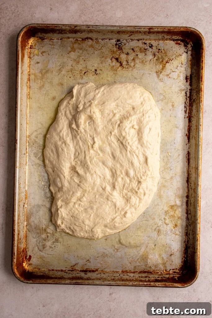 Authentic Italian Focaccia Bread Recipe 7 focaccia dough on an oiled sheet pan.
