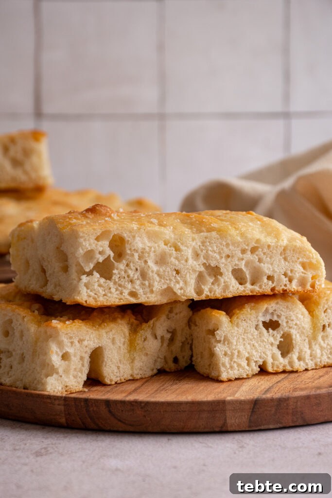Authentic Italian Focaccia Bread Recipe 10 focaccia bread sliced open to reveal an airy inside and a golden brown outside.