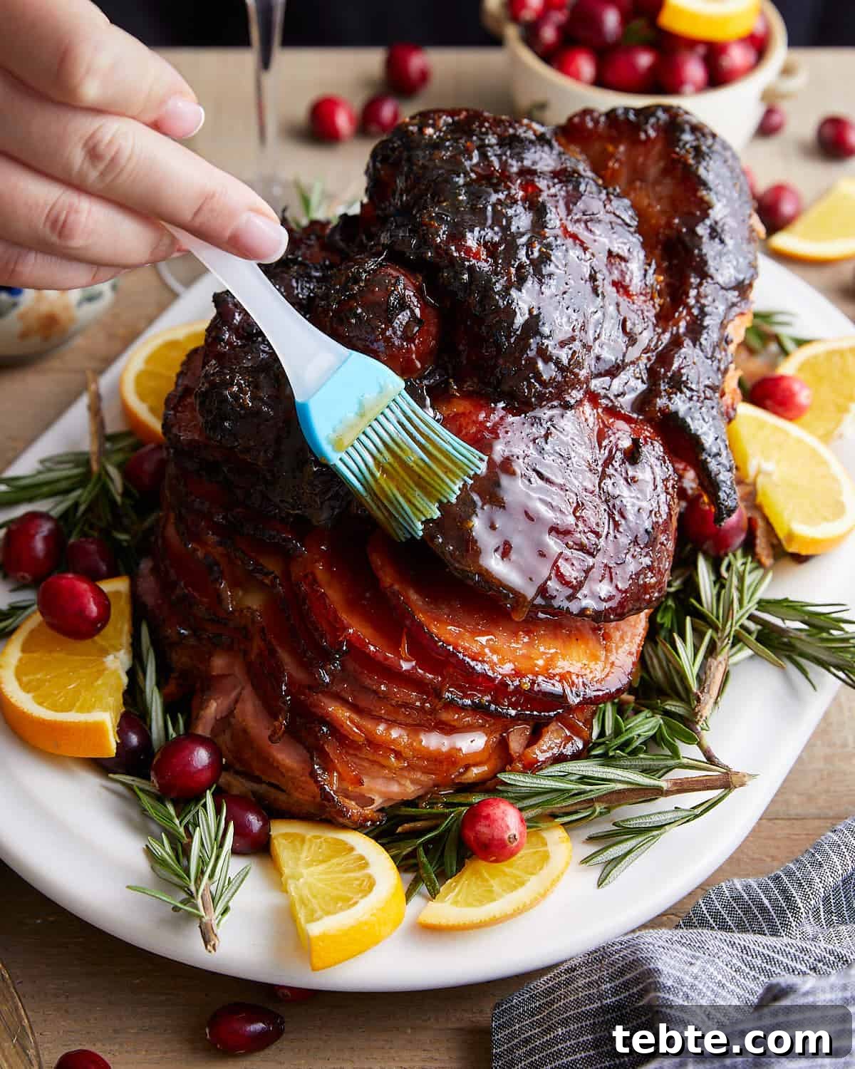 How to Cook a Spiral-Cut Ham for Juicy, Even Results 6 Image of spiral ham being topped with honey glaze.