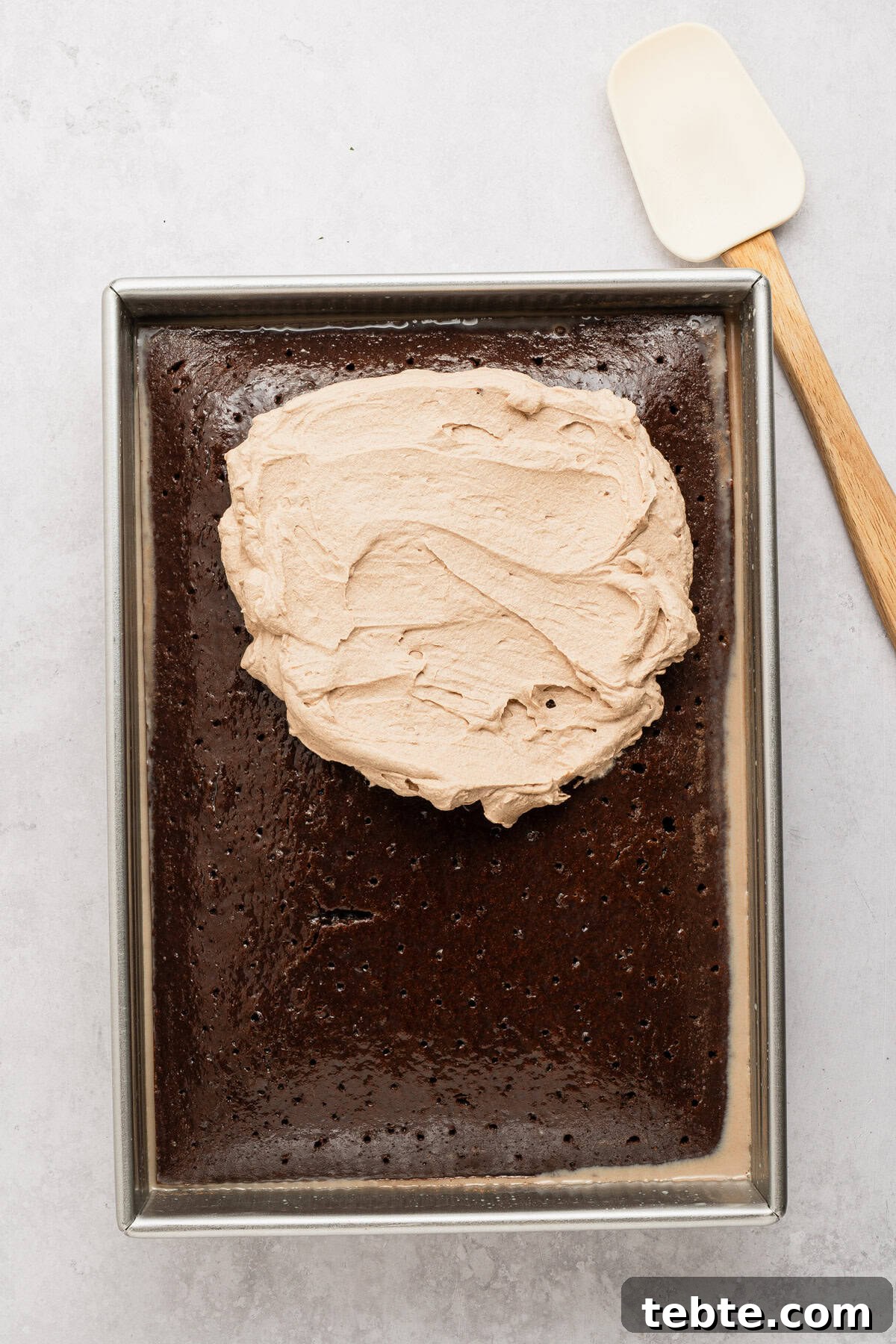 Decadent Chocolate Tres Leches Cake Recipe 6 Topping cake with whipped cream.