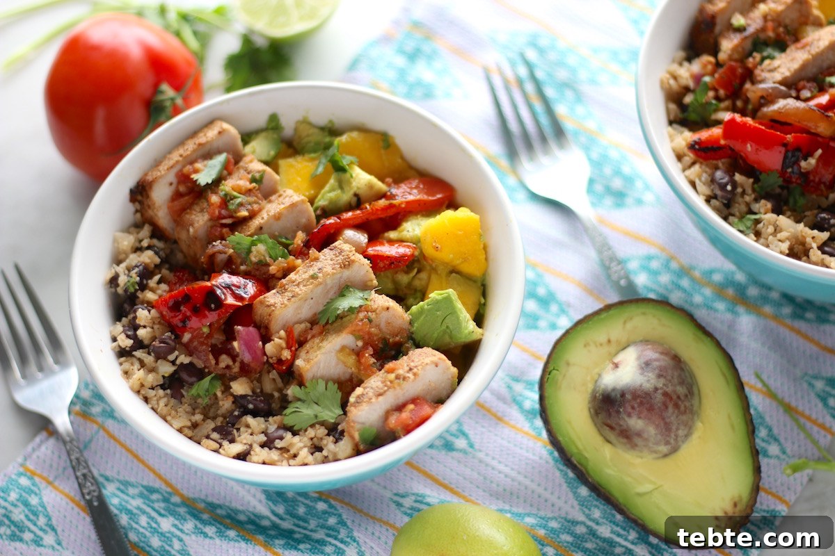 Grilled Pork Burrito Bowls - a crazy delicious bowl of grilled pork ribs, charred peppers and onions, cauliflower rice and beans, mango guac, and fresh salsa! YUM!!! | fedandfulfilled.com