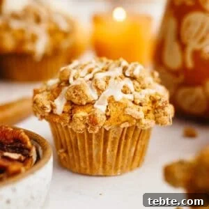 Pumpkin Pecan Muffins with Crunchy Pecan Streusel 15 A close up of a pumpkin pecan muffin with a white glaze.