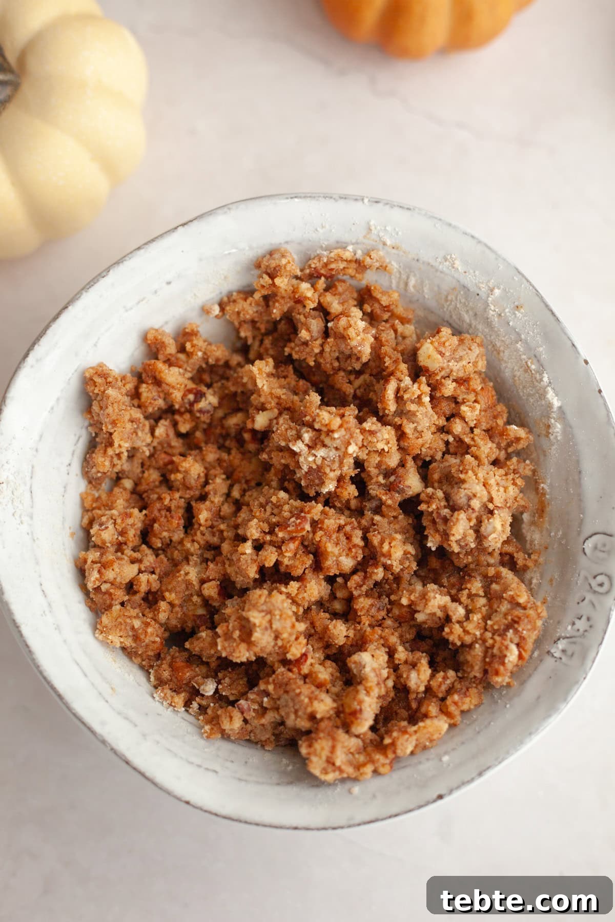 Pumpkin Pecan Muffins with Crunchy Pecan Streusel 4 Pecan streusel in a small white bowl.