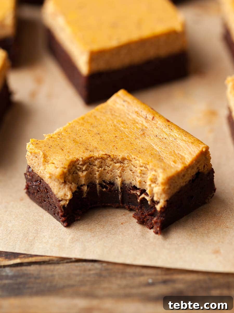 Gluten-Free Pumpkin Cheesecake Brownies Recipe for Fall Baking 19 a piece of pumpkin cheesecake brownies with a bite taken out