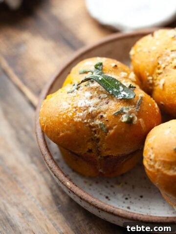 Soft, fluffy gluten free pumpkin dinner rolls with sage garlic butter—perfect for Thanksgiving and cozy fall meals. Easy to make and packed with cozy flavor!