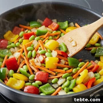 Veggies being sautéed  in nonstick pan. 