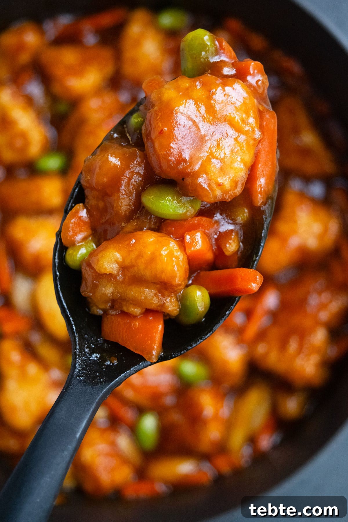 Closeup shot of spoonful of  breaded chicken and vegetables. 