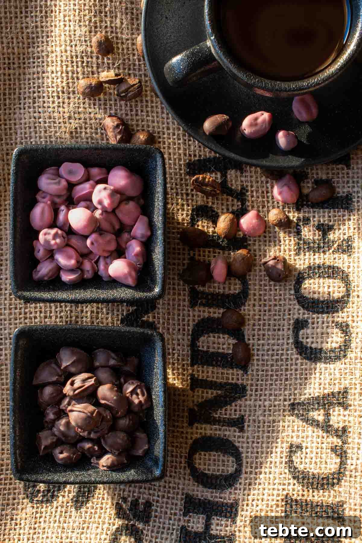 Homemade Chocolate-Covered Coffee Beans Recipe for Snacking 2 Ruby and dark chocolate covered coffee beans in black pots, on a coffee sack background.