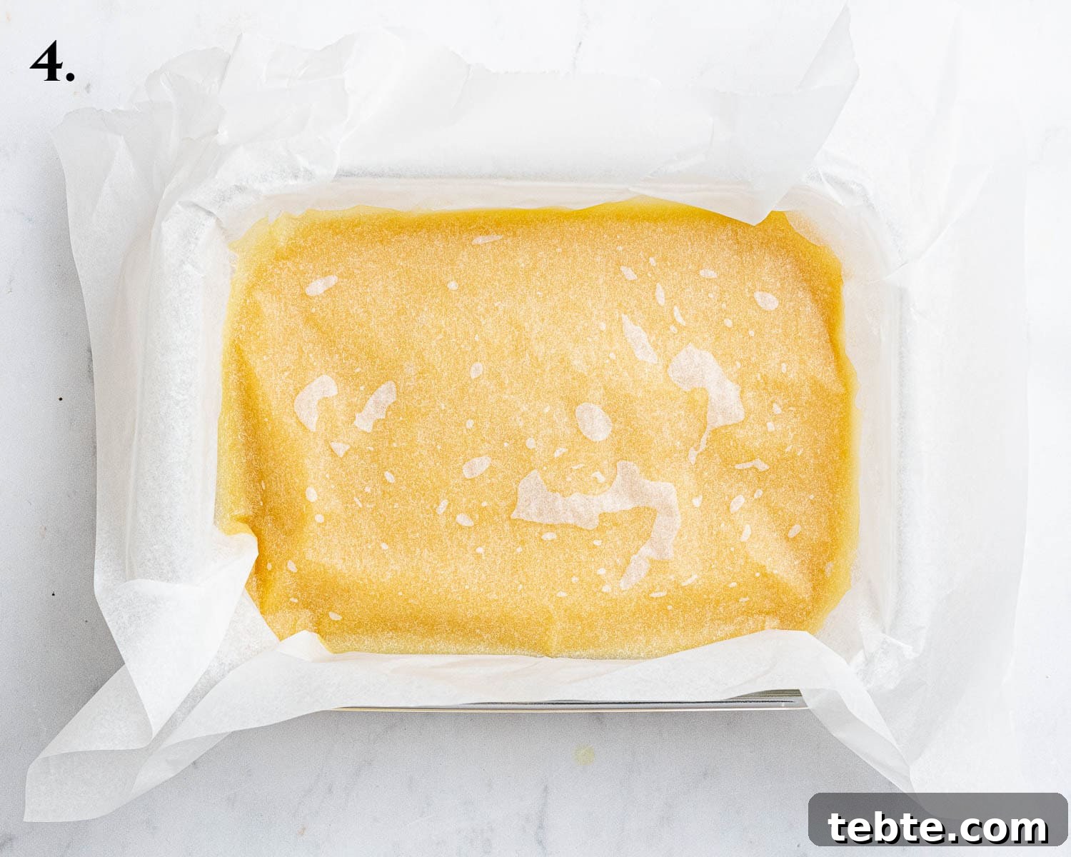 Vibrant Vegan Passion Fruit Curd Recipe for Tarts & Toast 8 Step 4, the curd in a container with baking paper on top.