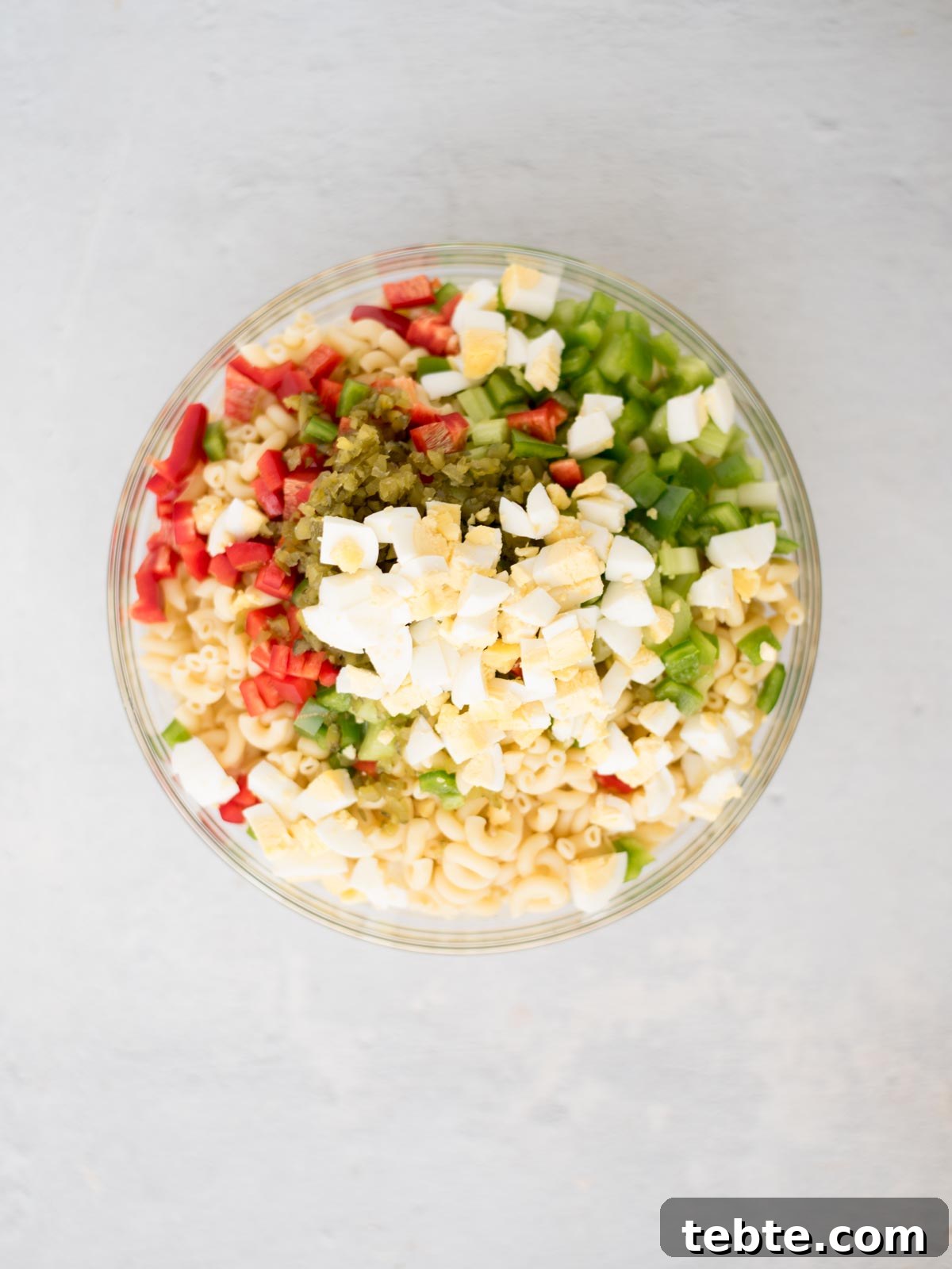 Grandma’s Old-Fashioned Macaroni Salad Recipe – Classic Comfort Food 5 All of the ingredients for southern macaroni salad in a glass mixing bowl before it's been mixed together.