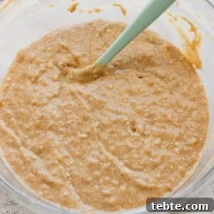 A bowl of thick, mixed batter with a green silicone spatula.