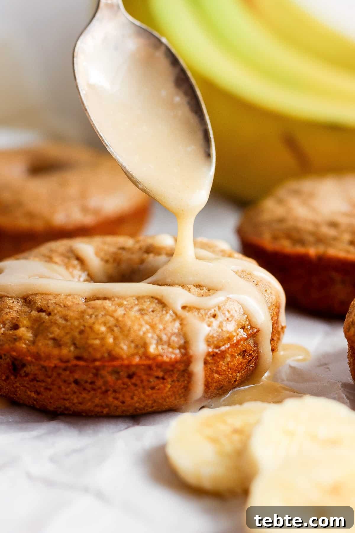 Drizzling icing onto freshly baked banana muffins.