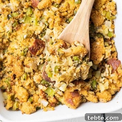 Southern Cornbread Dressing Recipe for Holiday Tables 8 A baking dish with cornbread stuffing shown garnished with fresh sage.