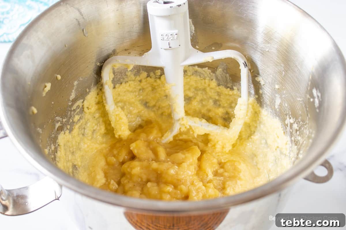 A mixing bowl filled with batter and mashed bananas.