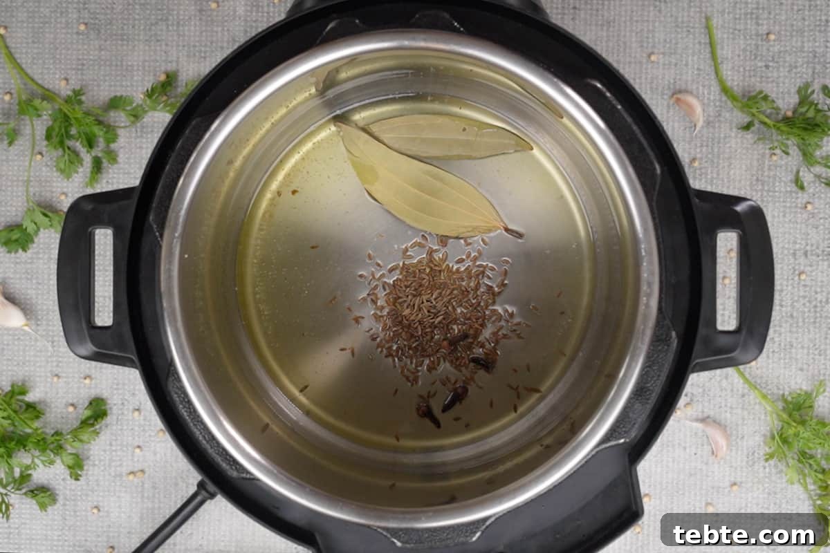 Jowar Khichdi Recipe: Wholesome Millet One-Pot Meal 7 Cumin seeds, bay leaves and cloves added to hot oil in instant pot.