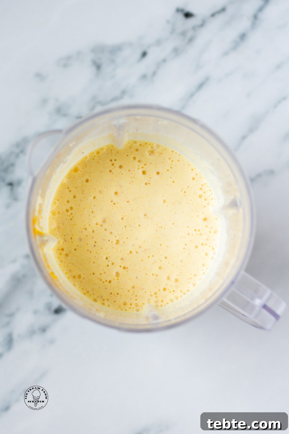 Creamy Pineapple Milkshake Recipe – Tropical Smoothie Treat 5 Overhead view of a pineapple milkshake in a blender jar