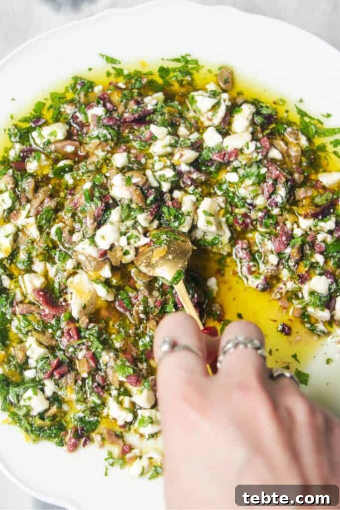 Jalapeño Popper Bread with Creamy Dipping Oil Recipe 8 Hand mixing ingredients for Greek dipping oil in a large white plate.