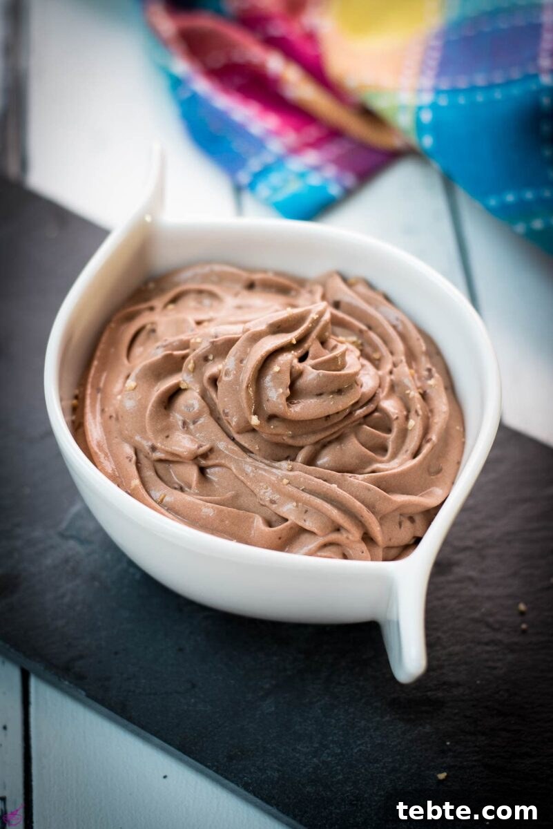 Rich Homemade Dark Chocolate Pudding Recipe — Silky & Decadent 2 White ceramic bowl filled with delicious dark chocolate pudding on black slate plate.