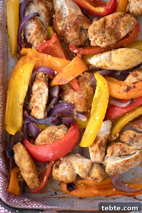 Sheet Pan Chicken Fajitas for Quick Weeknight Dinners 3 Baked sheet pan chicken fajitas with red, orange, and yellow peppers.