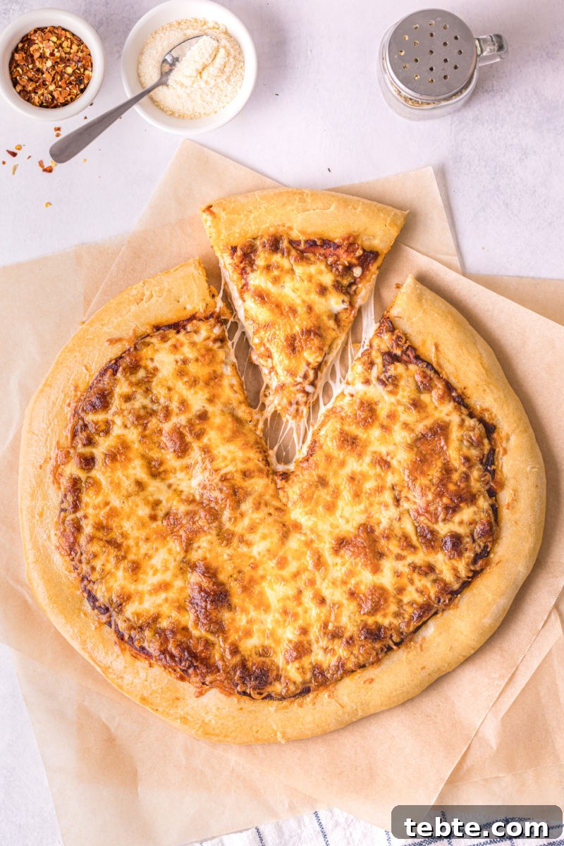 looking down at a cheese pizza slice pulled away from the rest of the pizza