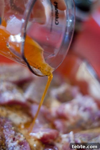 Orange Sticky Finger RIbs | Heather Likes Food orange soda being poured over the ribs