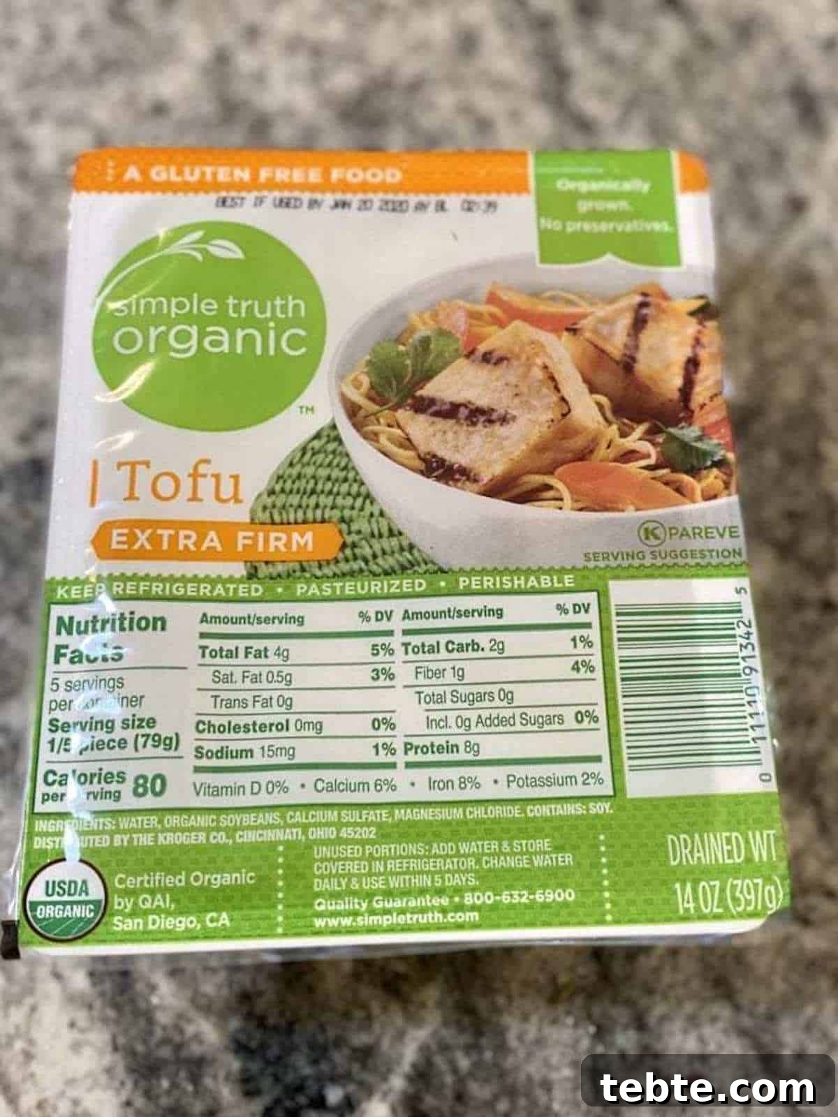 A package of extra firm tofu on the counter. 