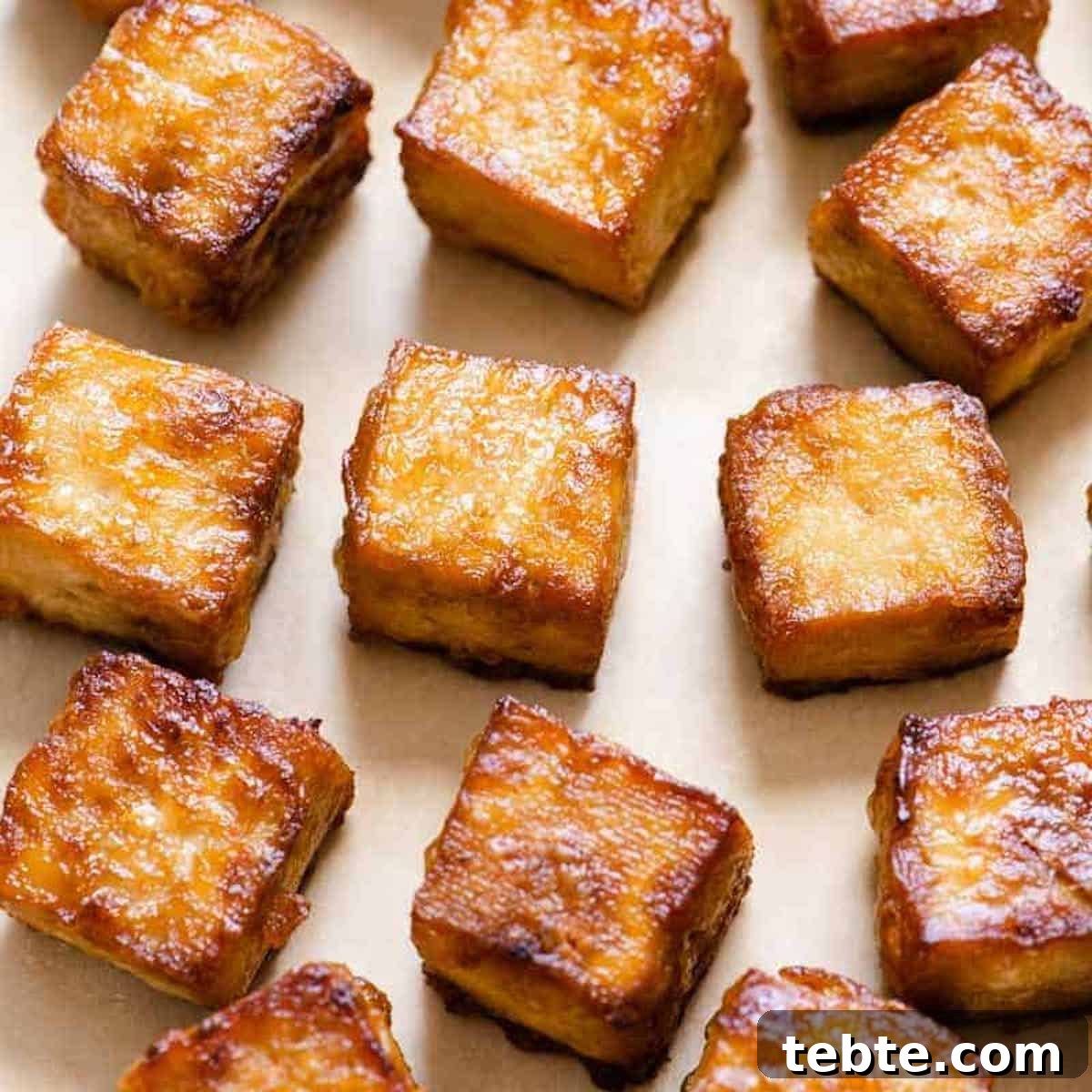 I am learning to cook tofu pieces on a baking sheet with parchment paper.