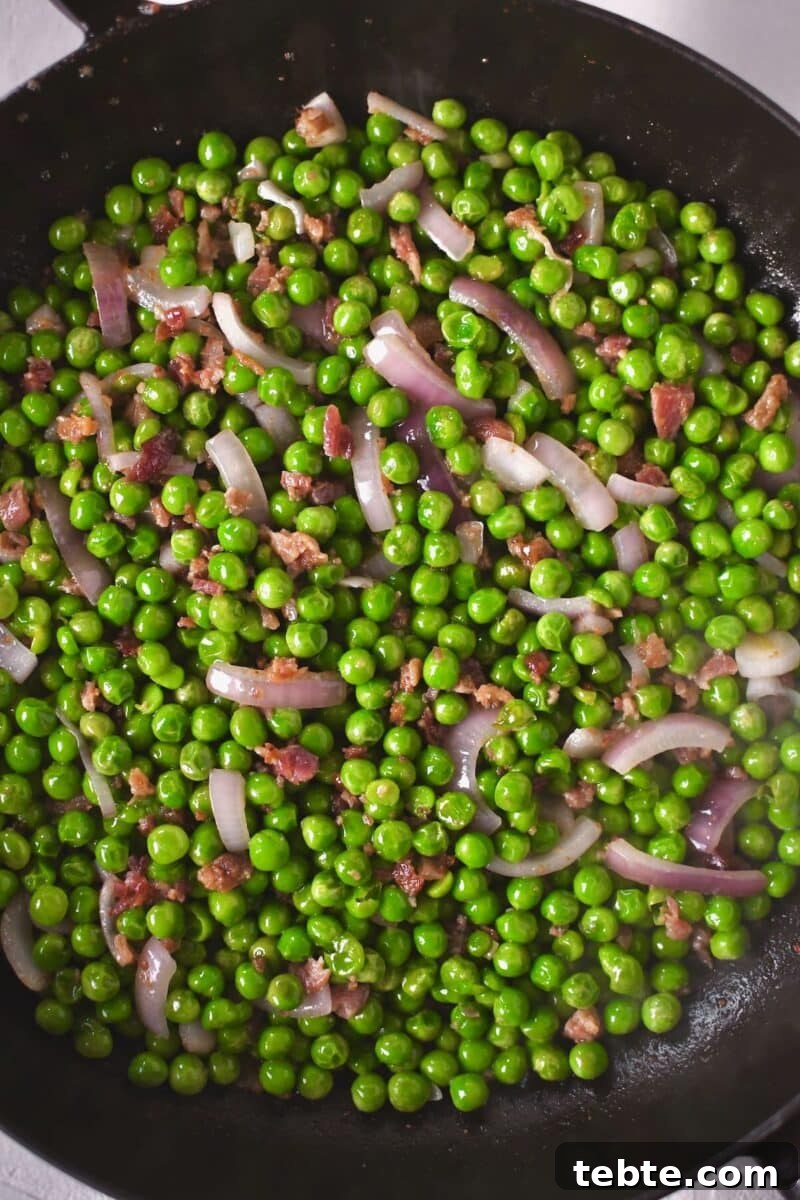 Creamy Pea Salad with Bacon and Red Onion 5 Peas cooking with red onion and bacon bits added to them.