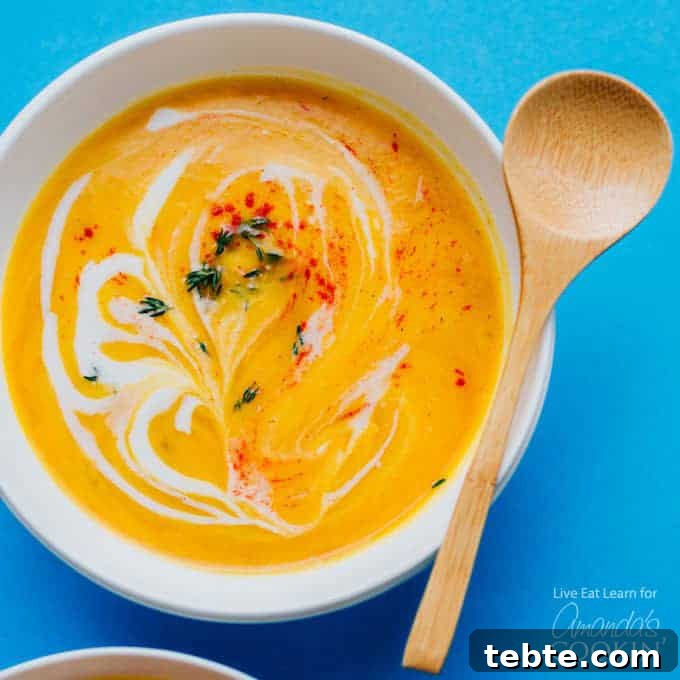 creamy cauliflower soup in a bowl with wooden spoon