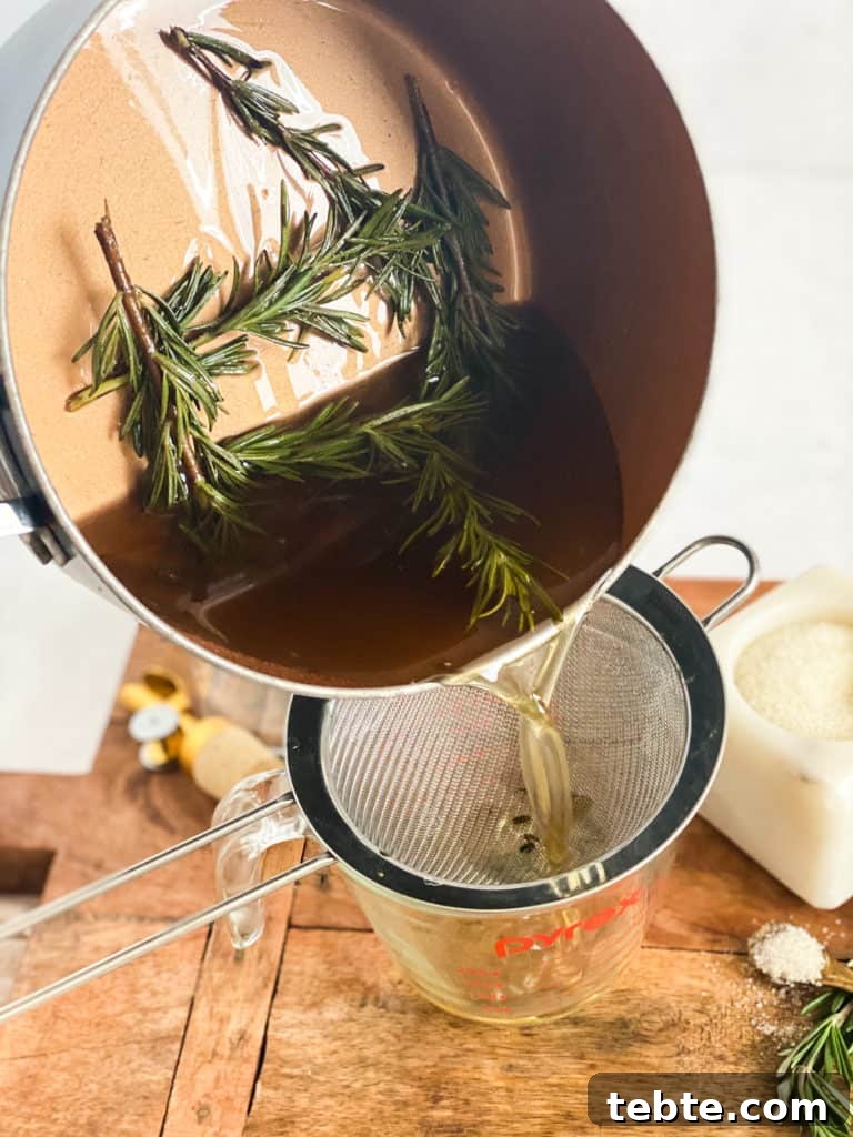 Rosemary Simple Syrup being poured into a strainer