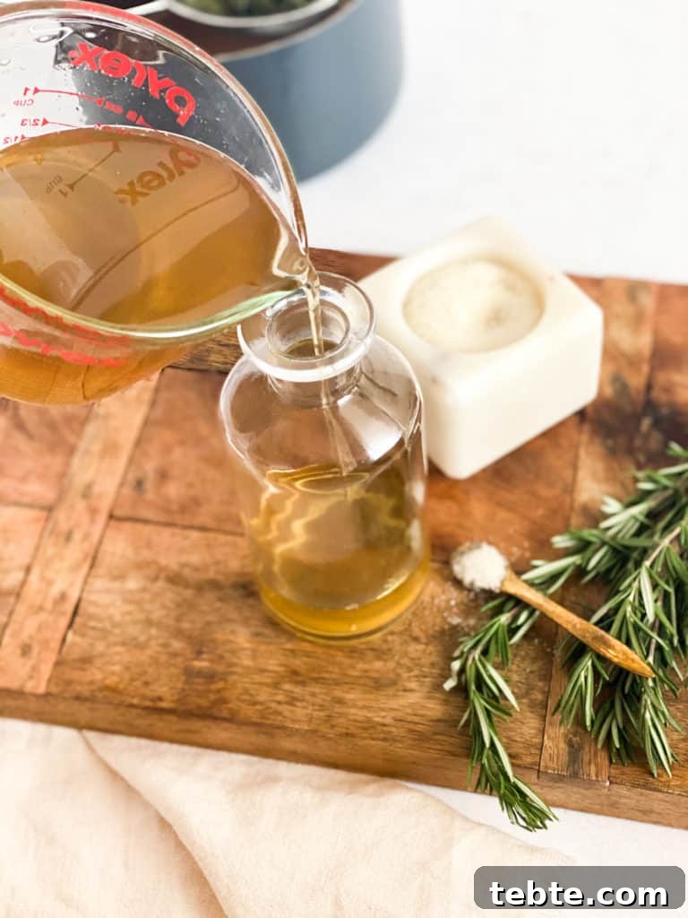 Rosemary Simple Syrup being poured into a glass jar