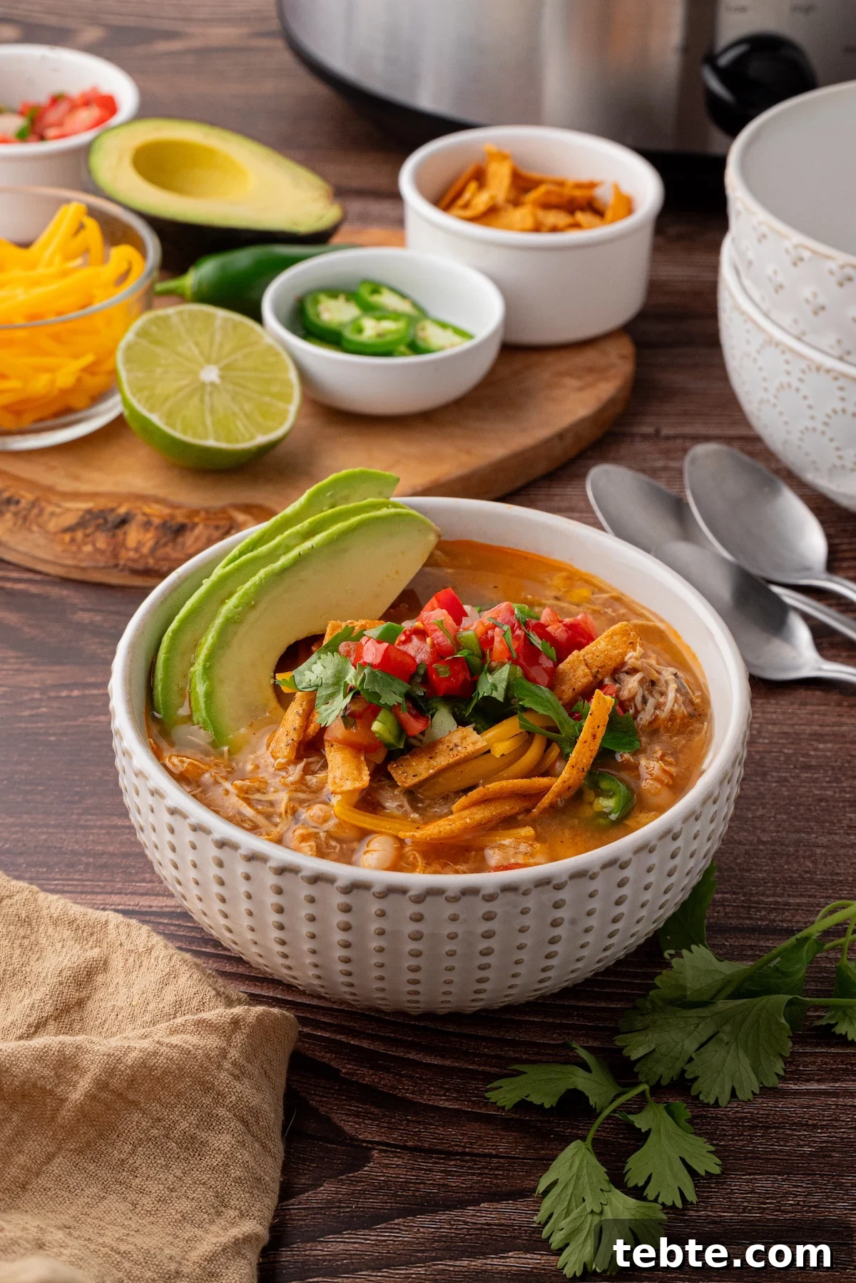 Slow-Cooker White Chicken Chili Recipe (Low-Calorie Crock-Pot) 6 bowl of soup with avocado slices, tortilla strips and pico