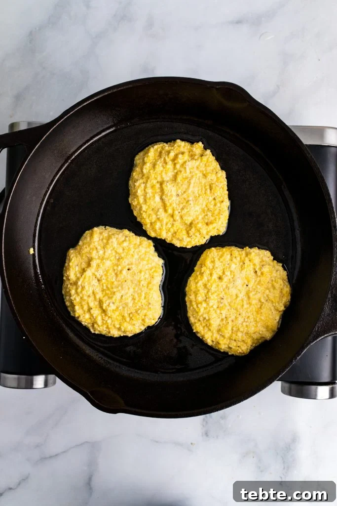 hot water cornbread batter in three cakes in a cast iron skillet