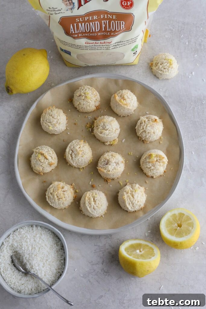 Lemon Almond Macaroons Recipe: Zesty Gluten-Free Cookies 6 Lemon Almond Flour Macaroons on parchment lined plate with lemons and shredded coconut on the side