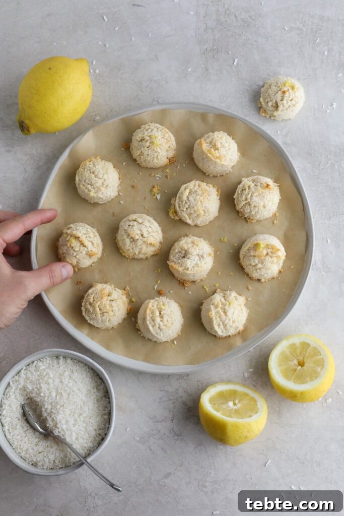Lemon Almond Macaroons Recipe: Zesty Gluten-Free Cookies 7 Lemon Almond Flour Macaroons on parchment lined plate with lemons and shredded coconut on the side