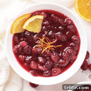 Cranberry Sauce for Instant Pot: Quick Holiday Recipe 8 Bowl of instant pot cranberry sauce, garnished with orange slices and zest.