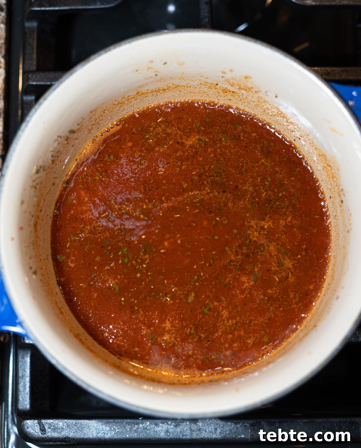 Homemade Red Enchilada Sauce Recipe for Authentic Flavor 7 Enchilada sauce cooking in a pan on the stove.