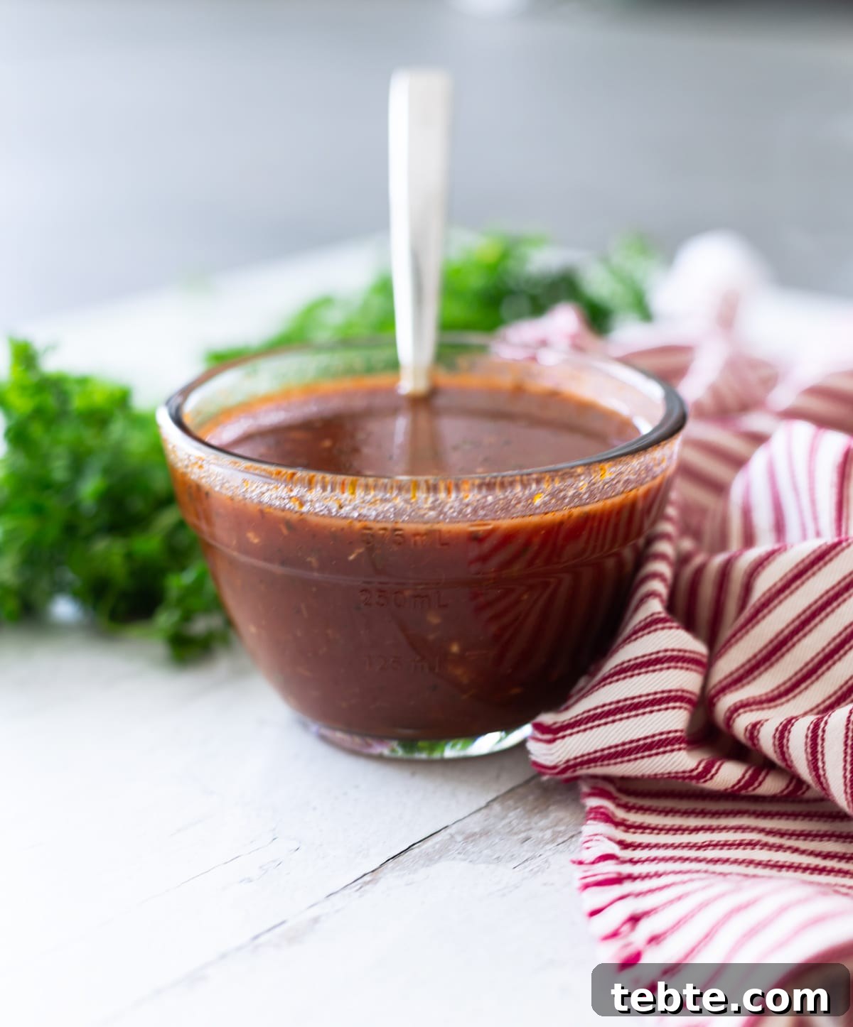 Homemade Red Enchilada Sauce Recipe for Authentic Flavor 9 Red enchilada sauce in a glass container on a counter.