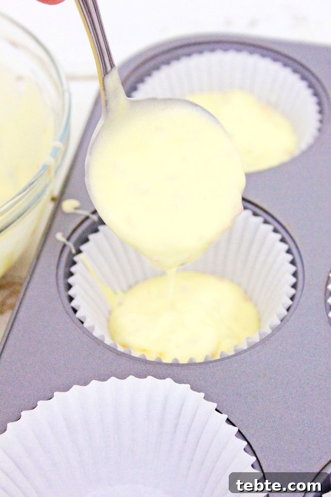 cupcake batter being ladled into a cupcake pan
