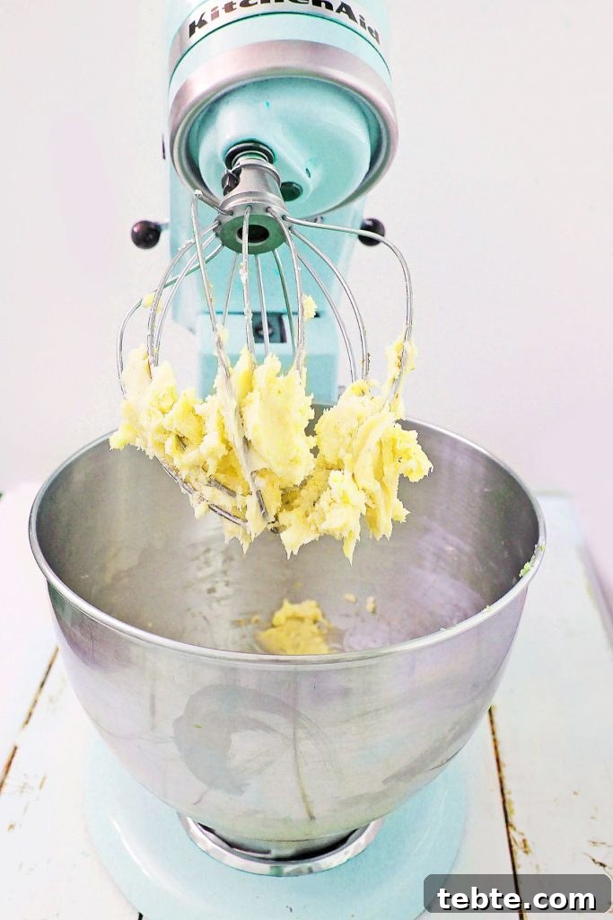 butter and sugar being creamed in a stand mixer