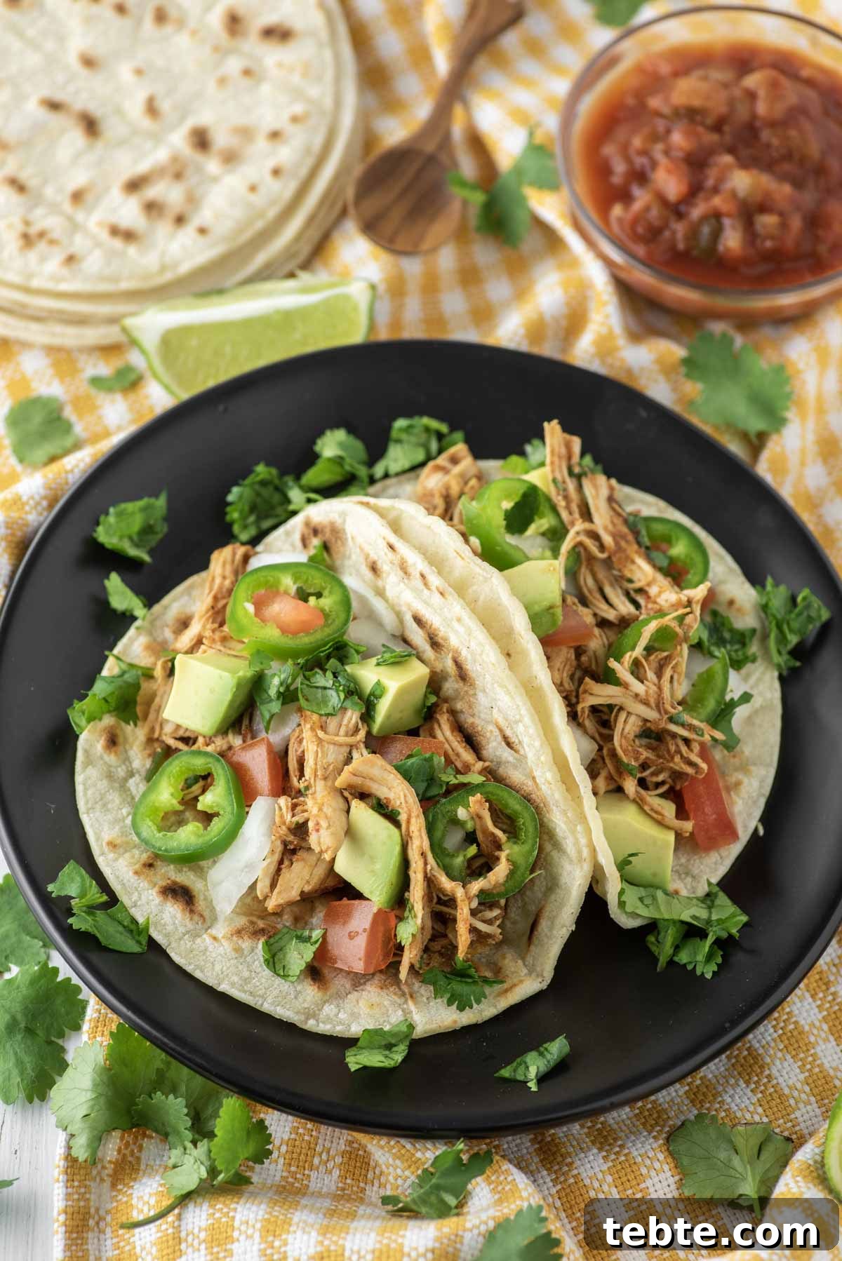 shredded chicken tacos on black plate