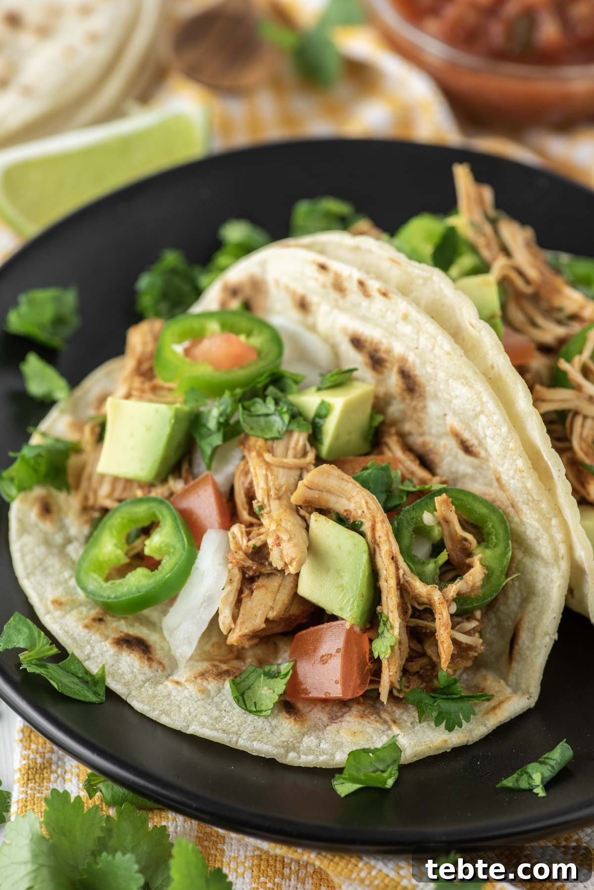 two Instant pot chicken tacos on black plate