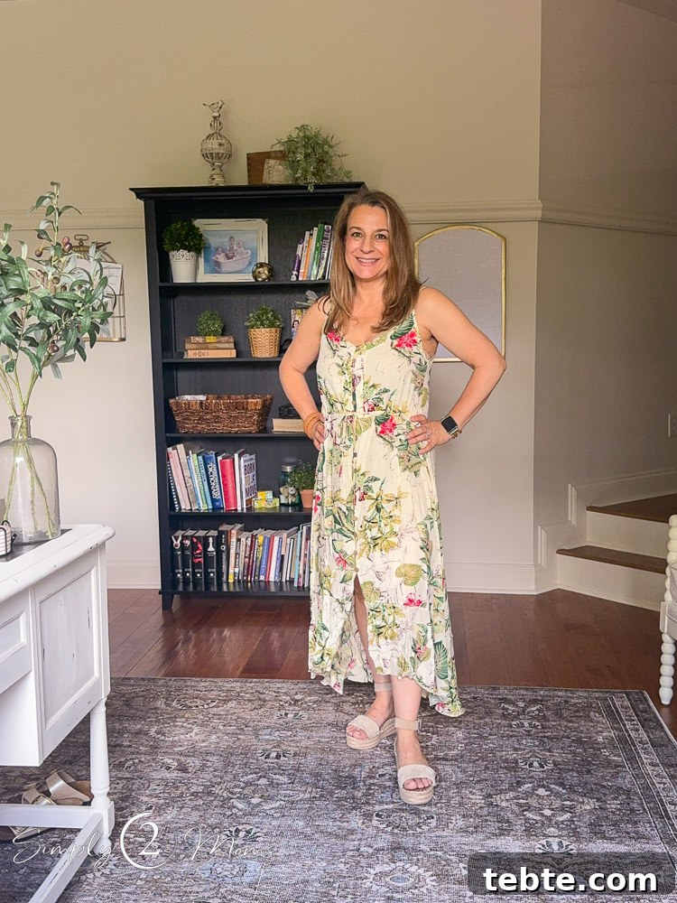 8 Adorable Amazon Jumpsuits and Sundresses You’ll Love 22 Woman wearing floral sundress with high low hem that buttons down the front with a tie at the waist.